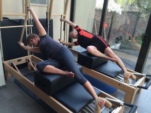 Pilates oefening op Reformer: side sit-up with stick               
